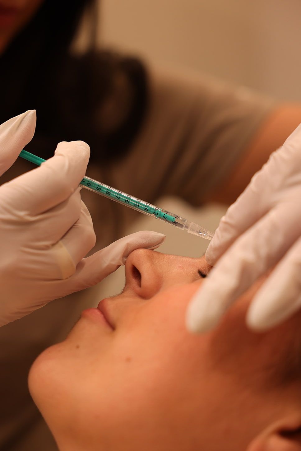 Administering an injection for cosmetic treatment.