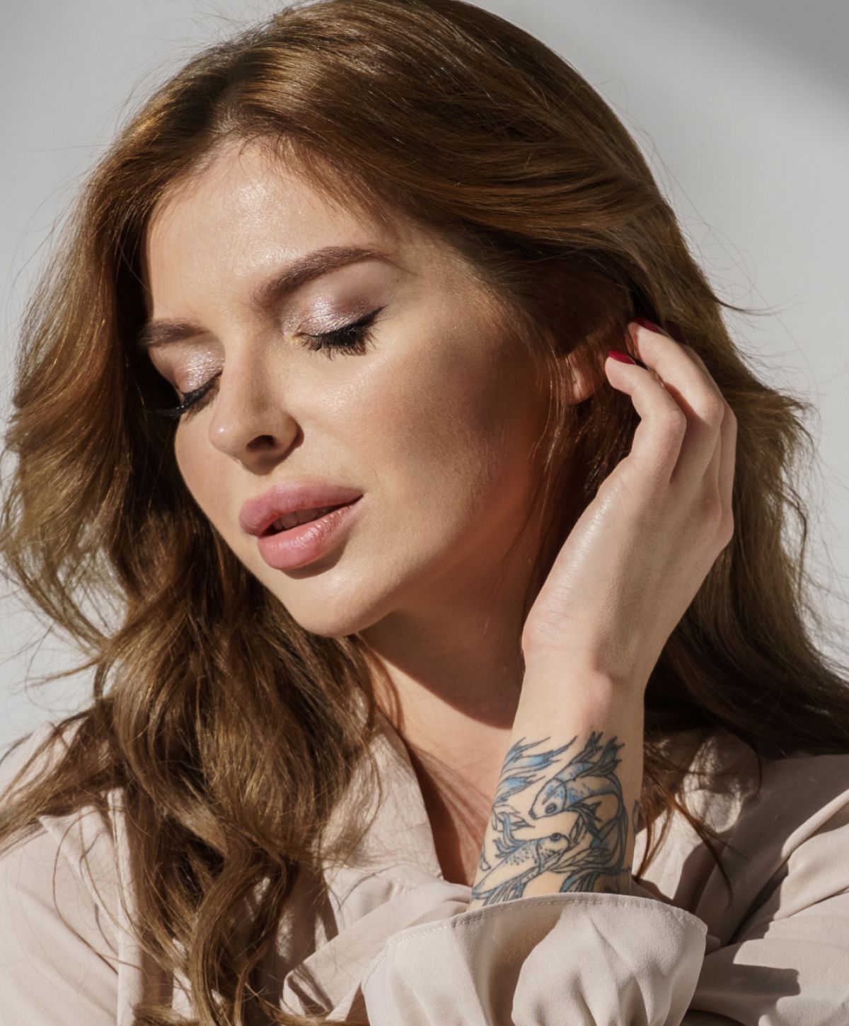 Dedham lip filler model with tattoo, looking contemplative and serene.